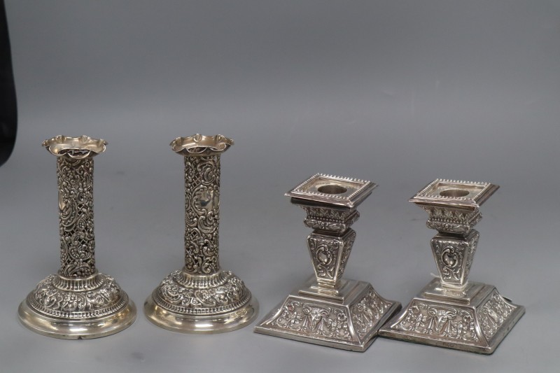 Two pairs of late Victorian silver dwarf candlesticks,